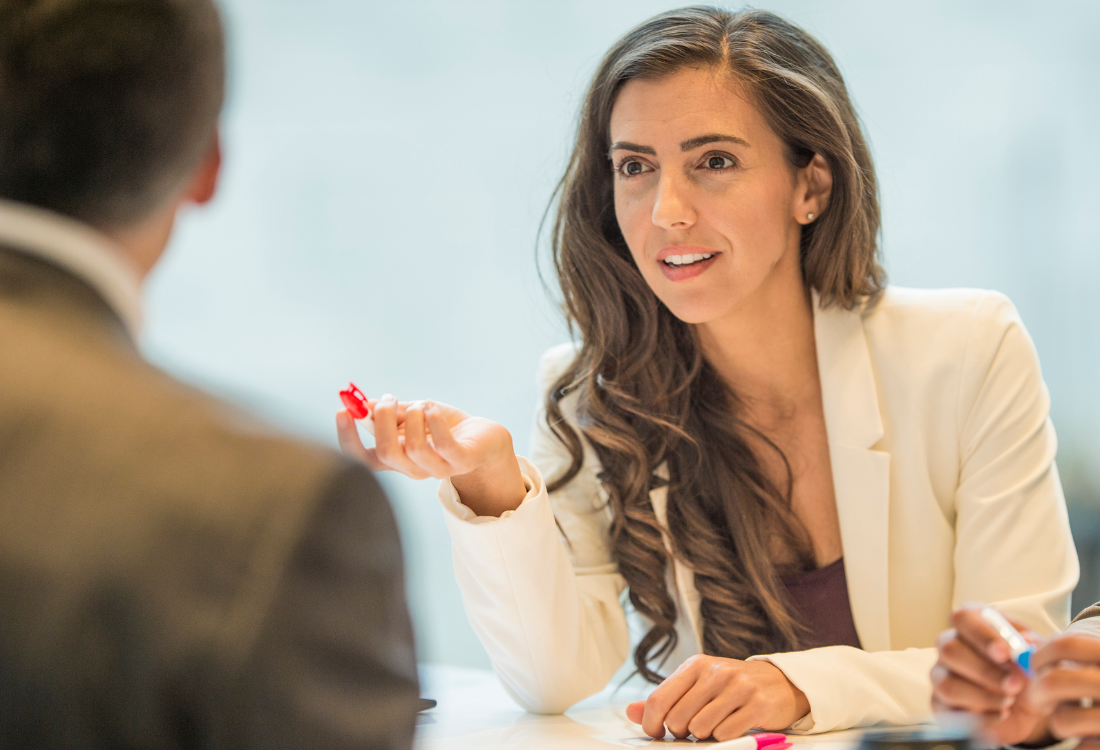 A woman in a one to one meeting using negotiation to resolve conflict.