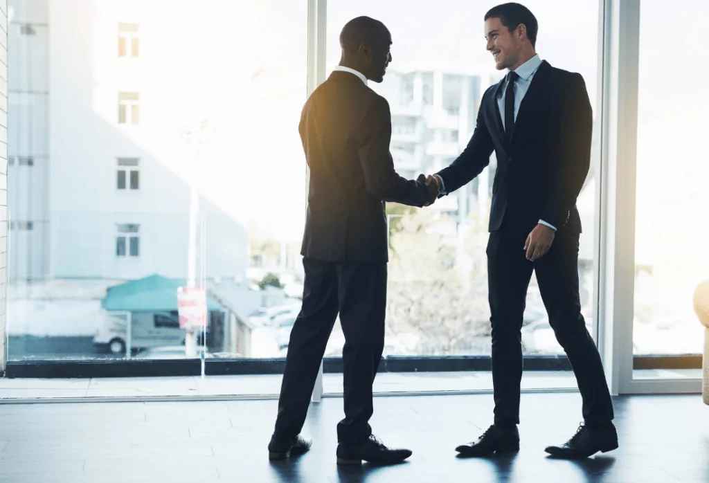 Two business men shaking hands showing their good workplace relationship. 