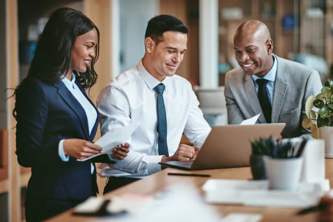 Three salespeople looking at ways to build customer advocacy in their business.