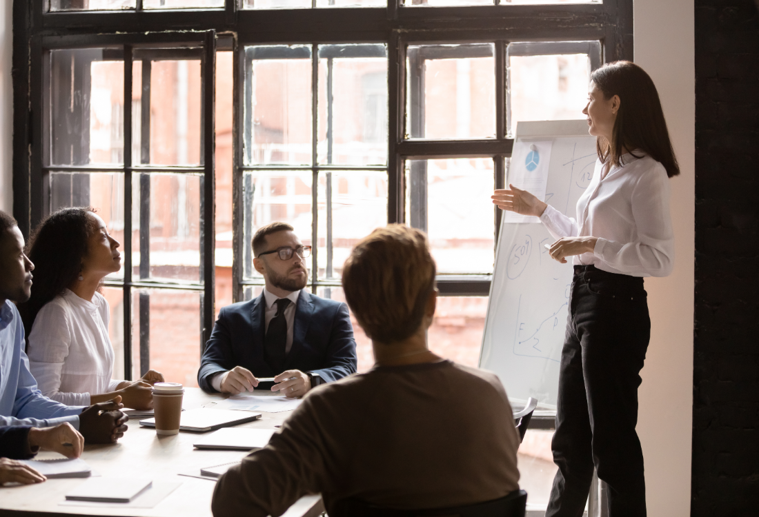 Sales trainer presenting to employees during a team workshop session. 