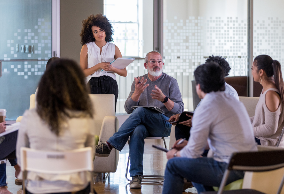 A group of managers in a meeting room taking part in business management skills training.