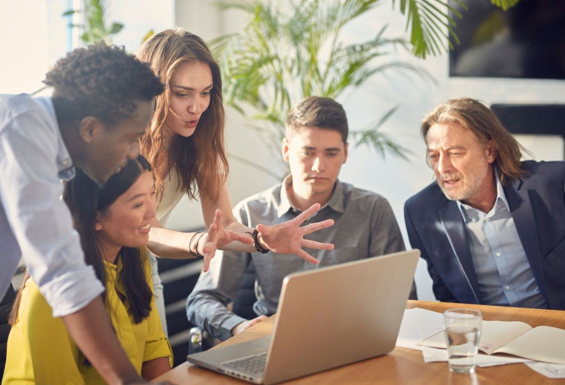 A group of employees receiving a mentoring session in the workplace. 